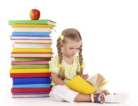 Little girl reading  pile of books. Isolated.